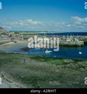 Low tide in the harbour Seahouses Northumberland UK with fishing boat ...