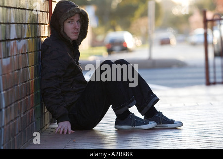 young teenage boy teenager rebellious male youth graffiti brick wall melbourne Stock Photo