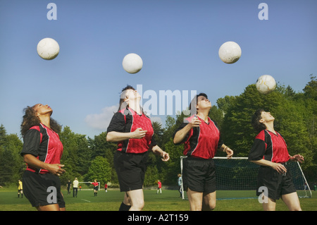 Four young female soccer players heading balls Stock Photo