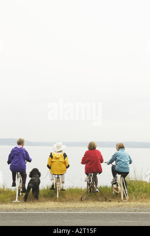 Four women on stationary bikes Stock Photo