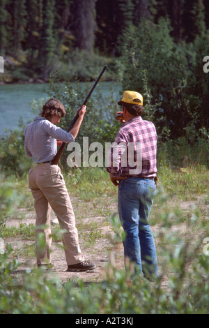 Female Hunter holding Hunting Rifle, Woman learning to shoot Gun, Northern BC, British Columbia, Canada Stock Photo