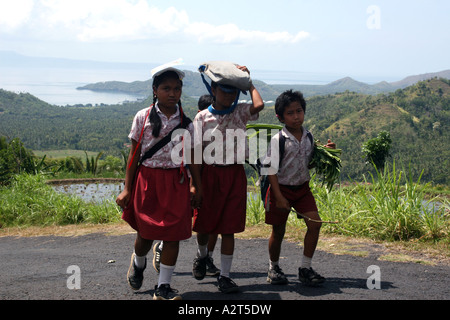 Balinese School-children on their way home in Bali Mountains, rice terraces in the background Stock Photo