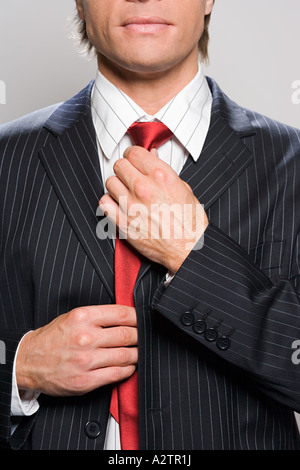 Businessman adjusting tie Stock Photo