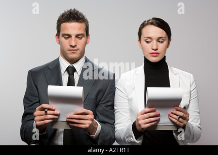 Businesswoman looking at colleagues notebook Stock Photo