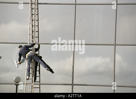 window cleaner stretching from ladder, swindon, uk Stock Photo