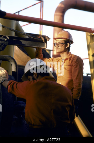 two men workers wearing helmets oil industry wilhwmosa mexico Stock Photo