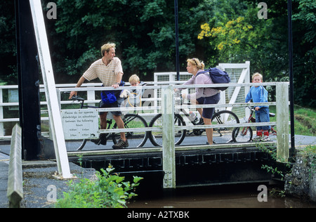 Family cycling on lift bridge on the Monmouthshire and Brecon Canal at Talybont on Usk, Brecon Beacons, Wales, GB Stock Photo