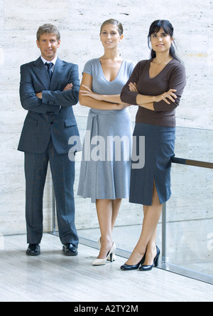 Three business executives standing with arms folded, full length portrait Stock Photo