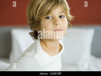 Little boy, bed in background Stock Photo