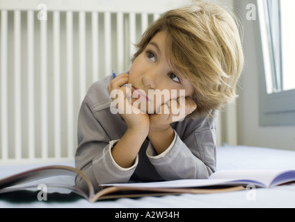 Boy doing homework, looking up Stock Photo