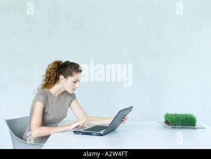 Woman using laptop computer at table Stock Photo