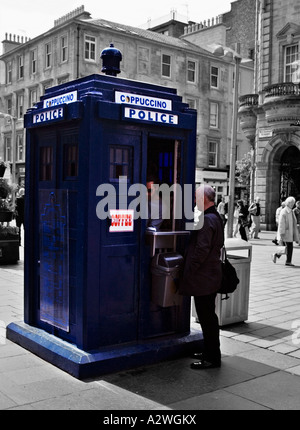 A man buying a drink from an old police box that has been converted into a coffee kiosk, Buchanan street Glasgow Stock Photo