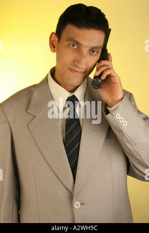 DPA 98293 South Asian Indian smart man in  executive dress suit tie talking cordless phone mobile cellphone  Model Release 623 Stock Photo