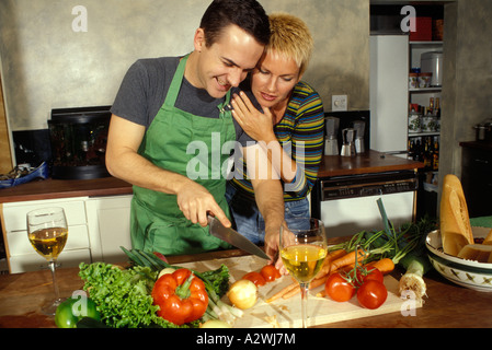 Woman embracing man in kitchen, smiling Stock Photo