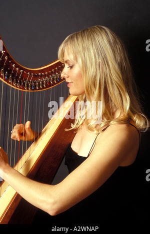 Young woman playing harp Stock Photo