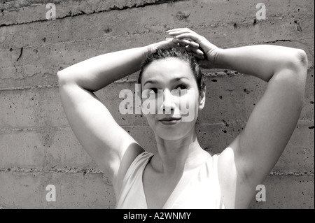 Young woman standing by wall Stock Photo