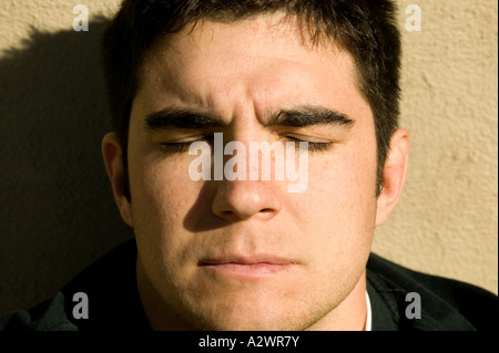 Young man by wall, close up Stock Photo