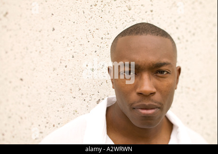 Young man standing by wall, portrait Stock Photo