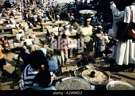 A woman carries her goods in a metal bowl on her  head in Freetown market, Sierra Leone, Africa Stock Photo