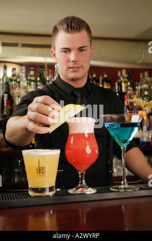 Barman prepares a Planters Punch The Cocktails from the left Whiskey Sour Planters Punch Blue Lady Stock Photo