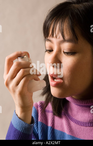 Woman using bronchial inhaler to relieve asthma symptoms. Stock Photo