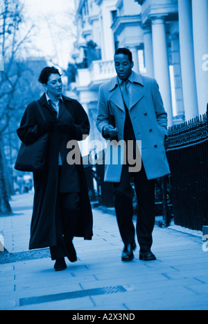 Man and woman walking in London city street. Stock Photo