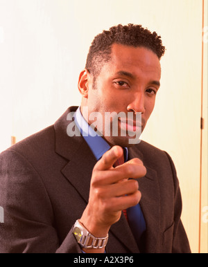 Portrait of young man in business suit. Pointing his finger. Stock Photo