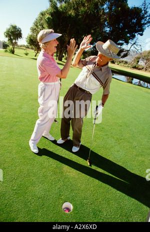 Retirement age man and woman enjoying game of golf together. Stock Photo