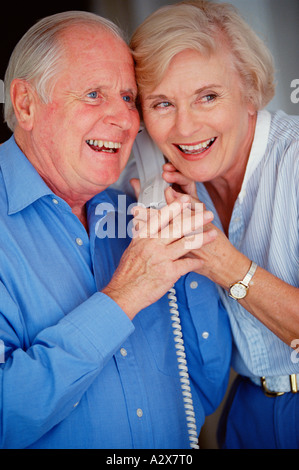 Indoor close-up of old couple talking on the telephone. Stock Photo