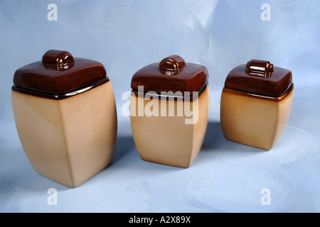 Three Stoneware Storage Jars against a blue background Stock Photo