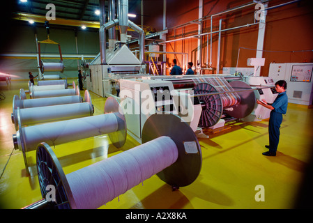 Workers operating machinery in toweling factory. Indonesia. Stock Photo