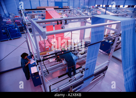 Workers operating machinery in toweling factory. Indonesia. Stock Photo