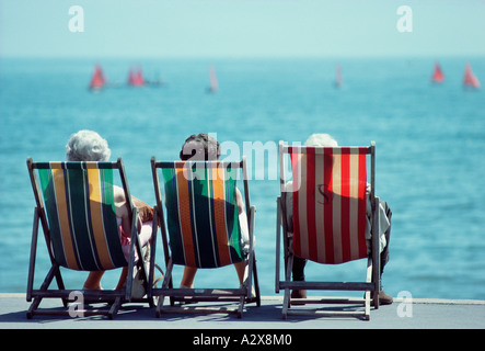 Three old ladies sitting in deckchairs on seaside promenade. Stock Photo