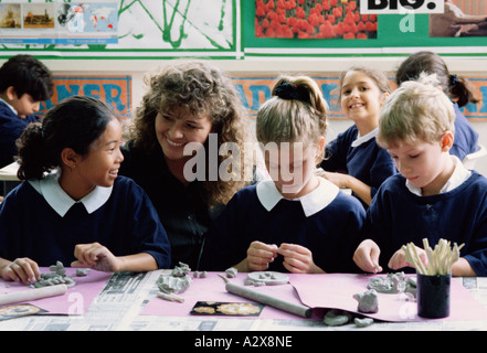 Happy children with teacher in classroom Stock Photo - Alamy