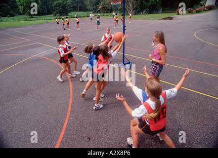 School children playing netball game in outdoors playground. Stock Photo