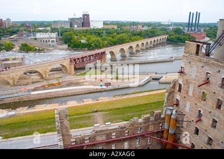 Mississippi River flows under Stone Arch Bridge and by Mill Ruins Park viewed from Mill City Museum. Minneapolis Minnesota USA Stock Photo