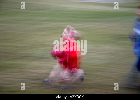 Blurred boy age 6 running with football. Plainfield Illinois USA Stock Photo
