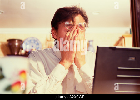 Close-up of tired young man with hands covering face. Stock Photo