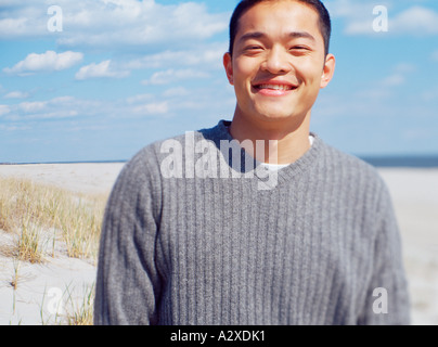 Outdoor beach portrait of young man wearing a gray sweater. Stock Photo