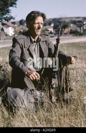 A Bosnian Serb soldier with his AK 47 rifle waits for a lift to the front line near Zvornic after some home leave Stock Photo