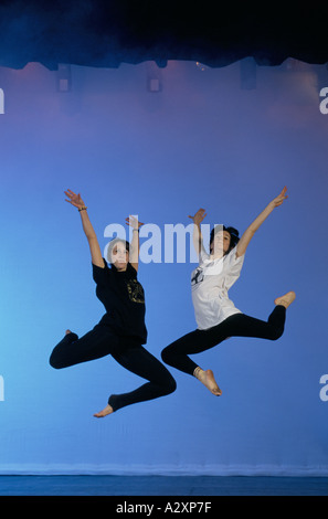 Two female dance student in mid flight as they make leaping jump durning rehearsal at Liverpool Institute Of Performing Arts Stock Photo