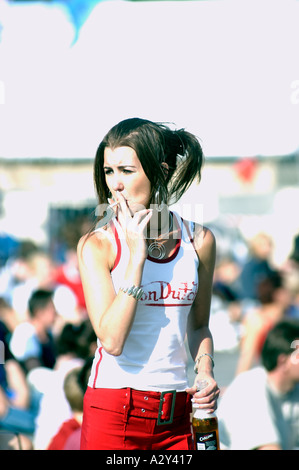 athletes smoking cigarettes woman smoking cigarette and holding a bottle of beer Stock Photo