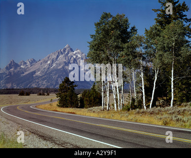 Grand Teton National Park in Wyoming showing a curving highway leading to a view of the high peaks Stock Photo