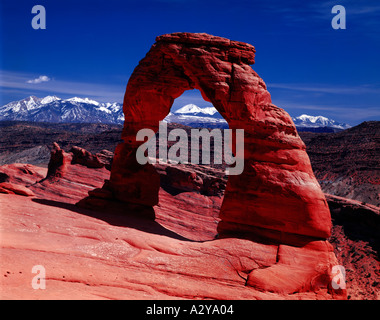 Arches National Park in Utah showing the red rocks of Delicate Arch viewed against the snowcovered LaSal mountain Stock Photo