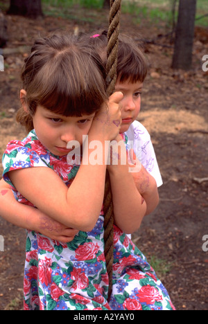 Sisters comforting each other on rope swing age 5 and 4. Downers Grove Illinois USA Stock Photo