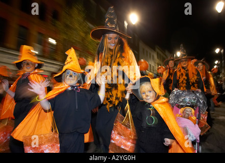 schoolchildren and teachers dressed as orange pumpkins parade down shipquay street Halloween Derry Ireland Stock Photo