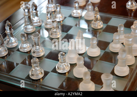 Glass pieces on a wooden chess board Stock Photo