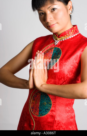 Close-up of chinese woman greeting and wearing traditional dress Stock Photo