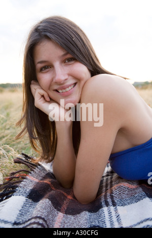 Portrait of a beautiful girl lying down on a blanket outdoors Stock Photo