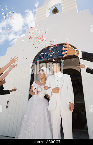 Guests throwing confetti over newlyweds Stock Photo